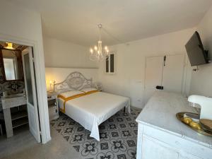 ein Schlafzimmer mit einem Bett und ein Badezimmer mit einem Waschbecken in der Unterkunft Favolosa stanza gialla con terrazzino vista mare Mottino23 in Lerici