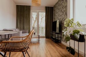uma sala de estar com um sofá, uma mesa e uma televisão em Salix Apartment em Brodnica