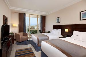 Cette chambre comprend deux lits et une télévision. dans l'établissement DoubleTree by Hilton Hotel Aqaba, à Aqaba