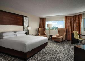 a hotel room with a bed and a desk and chairs at Hilton Atlanta Airport in Atlanta
