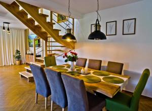 een eetkamer met een houten tafel en blauwe stoelen bij Domek Zacisze in Uherce Mineralne