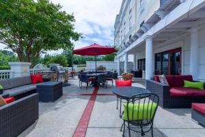 a patio with tables and chairs and an umbrella at Hampton Inn Lawrenceville Duluth in Lawrenceville