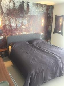 1 cama en un dormitorio con una pintura en la pared en Ubytování SR, en Milovice