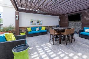 patio ze stołem, krzesłami i kanapą w obiekcie Homewood Suites by Hilton Lawrenceville Duluth w mieście Lawrenceville