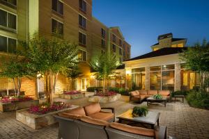 un cortile con divani e tavoli e un edificio di Hilton Garden Inn Atlanta NW/Kennesaw-Town Center a Kennesaw