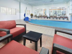 a hotel lobby with a pool and tables and chairs at Hilton Garden Inn Atlanta NW/Kennesaw-Town Center in Kennesaw