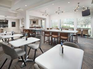 a dining room with white tables and chairs at Hilton Garden Inn Atlanta NW/Kennesaw-Town Center in Kennesaw