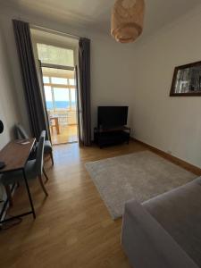 ein Wohnzimmer mit einem Tisch, einem Sofa und einem TV in der Unterkunft Frontiere de Monaco 3 Pieces Vue Mer in Cap d'Ail