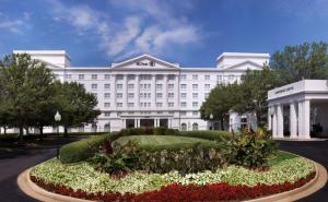 a white hotel with a garden in front of it at Hilton Atlanta/Marietta Hotel & Conference Center in Marietta