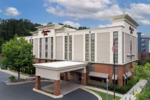 Un grande edificio bianco con una bandiera americana di Hampton Inn Atlanta-Mall Of Georgia a Buford