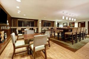 une salle à manger avec des tables et des chaises ainsi qu'un bar dans l'établissement Hampton Inn Atlanta-Mall Of Georgia, à Buford