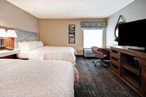 a hotel room with two beds and a flat screen tv at Hampton Inn Atlanta-Mall Of Georgia in Buford