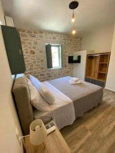 1 dormitorio con cama y pared de piedra en Mainotti's house with balcony, en Areopoli
