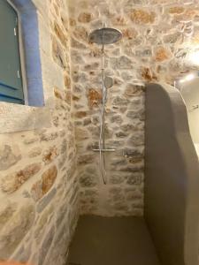 ducha en una habitación con pared de piedra en Mainotti's house with balcony, en Areopoli