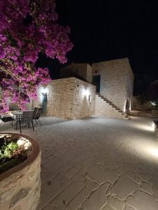 un edificio de piedra con patio por la noche en Mainotti's house with balcony, en Areopoli