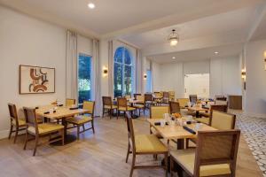 un restaurante con mesas y sillas de madera y ventanas en DoubleTree by Hilton Atlanta/Roswell - Alpharetta Area, en Roswell