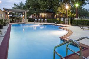 uma grande piscina com água azul à noite em DoubleTree by Hilton Austin-University Area em Austin