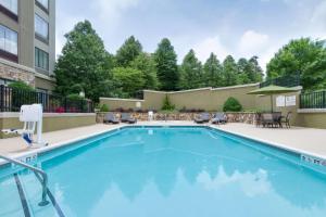 a swimming pool in a courtyard with a building at Hilton Garden Inn Atlanta Marietta in Atlanta