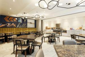 un restaurante con mesas y sillas y una cocina en DoubleTree by Hilton Austin-University Area en Austin