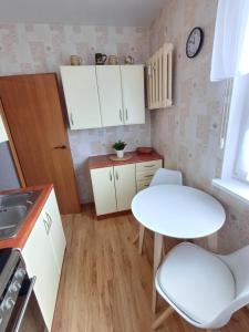 a small kitchen with a table and two chairs at Apartament Puck in Puck