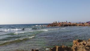 a group of people standing on a pier in the ocean at Villa 250 m2 terrasse plus Garage in Mostaganem