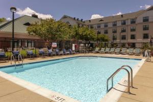 une grande piscine avec des chaises et un bâtiment dans l'établissement Homewood Suites by Hilton Columbia, à Columbia