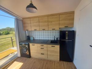 a kitchen with a black refrigerator and a dishwasher at Między Jeziorami in Ogonki