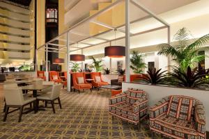 um átrio de um hotel com mesas e cadeiras em Embassy Suites Boca Raton em Boca Raton
