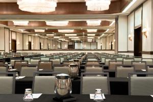 una sala de conferencias con mesas, sillas y lámparas de araña en Embassy Suites Boca Raton en Boca Raton