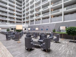 un gran vestíbulo con sillas y mesas en un edificio en Embassy Suites Baltimore - North/Hunt Valley en Hunt Valley