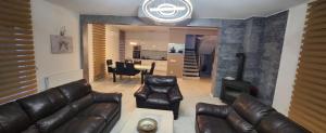 a living room with a leather couch and a fireplace at Villa „Taki“ Podgorica in Podgorica