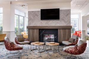 a living room with a fireplace and a flat screen tv at Hilton Garden Inn Bakersfield in Bakersfield