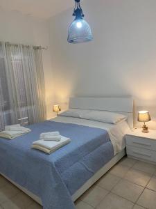 a bedroom with a bed with blue sheets and a lamp at Case sul mare in Palau