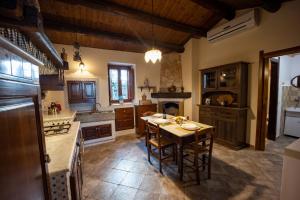 a large kitchen with a wooden table and chairs at Casale Della Contea in Modica