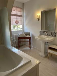a bathroom with a tub and a sink and a mirror at Belle Fontaine in Bourges