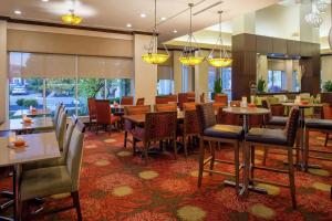 a dining room with tables and chairs in a restaurant at Hilton Garden Inn Boise Spectrum in Boise