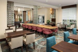 un restaurant avec des tables et des chaises en bois ainsi qu'un bar dans l'établissement Hilton Garden Inn Murfreesboro, à Murfreesboro