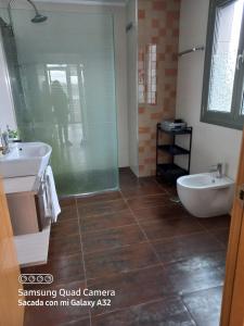 y baño con 2 lavabos, bañera y ducha. en Habitación en casa moderna con jardín, en Santa Cruz de Bezana