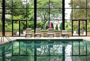 a swimming pool with chairs and a large window at DoubleTree by Hilton Boston-Milford in Milford