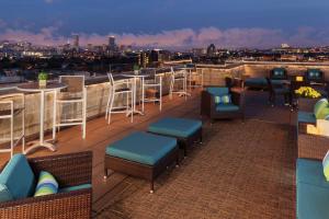 eine Dachterrasse mit Stühlen, Tischen und einer Skyline der Stadt in der Unterkunft DoubleTree Suites by Hilton Hotel Boston - Cambridge in Boston