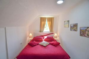 a bedroom with a red bed with two lamps at Planinska Oaza in Pale +13 photos