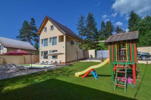 un patio con parque infantil con tobogán y una casa en Planinska Oaza, en Pale