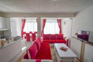 ein Wohnzimmer mit einem roten Sofa und einem Tisch in der Unterkunft Planinska Oaza in Pale