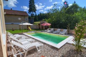 a swimming pool with chairs and a table and an umbrella at Planinska Oaza in Pale