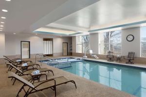 a large swimming pool with chairs and a clock at DoubleTree Suites by Hilton Hotel Boston - Cambridge in Boston