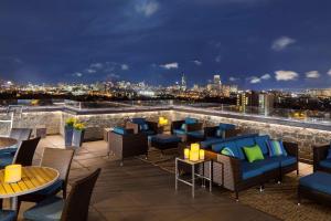 eine Dachterrasse mit Tischen und Stühlen und einer Skyline der Stadt in der Unterkunft DoubleTree Suites by Hilton Hotel Boston - Cambridge in Boston