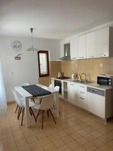 奈維斯的住宿－Apartments Njivice Bajcic，厨房配有桌椅和水槽。