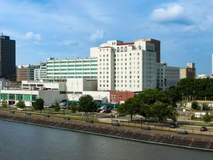 Hilton Baton Rouge Capitol Center في باتون روج: مبنى ابيض كبير بجانب تجمع المياه
