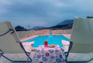 a table and chairs next to a swimming pool at Vila Rogač in Tivat