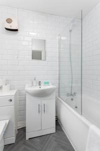 a white bathroom with a sink and a shower at Woodbine House - Air Host and Stay - Free parking - Contractor Friendly in Liverpool +21 photos